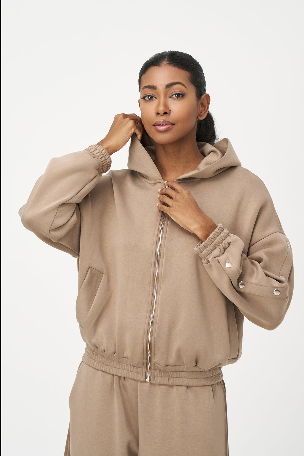 Beige zip-up hoodie with snap button sleeves and elastic cuffs and hem