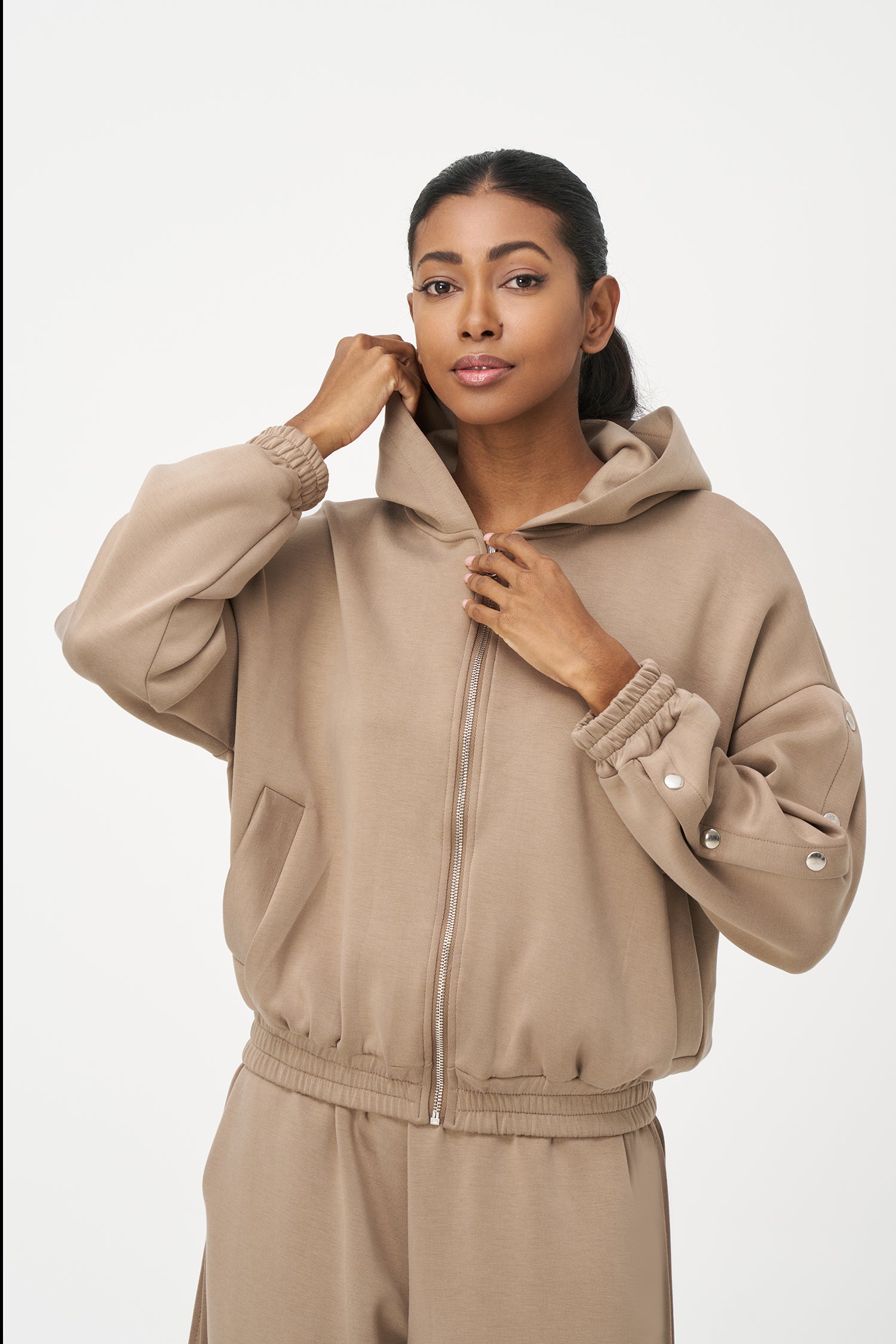 Beige zip-up hoodie with snap button sleeves and elastic cuffs and hem