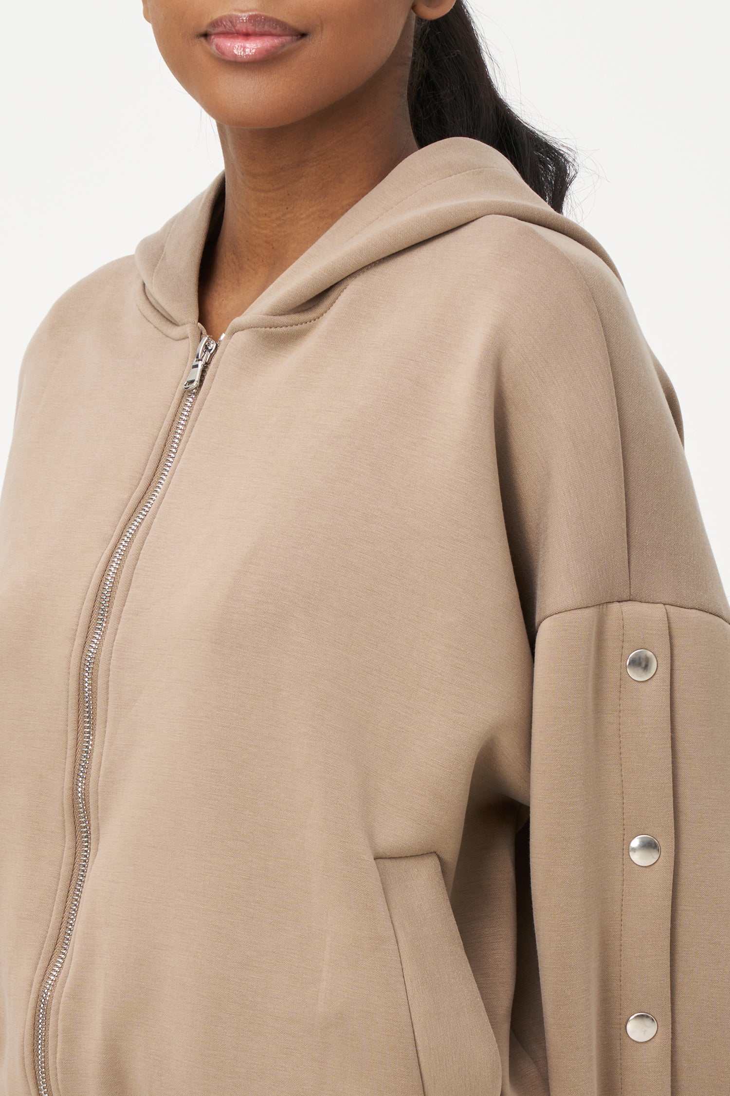 Beige zip-up hoodie with snap button sleeves and elastic cuffs and hem