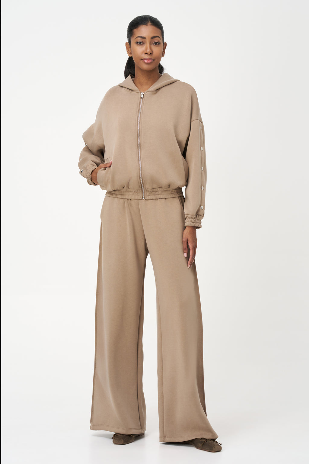 Beige zip-up hoodie with snap button sleeves and elastic cuffs and hem