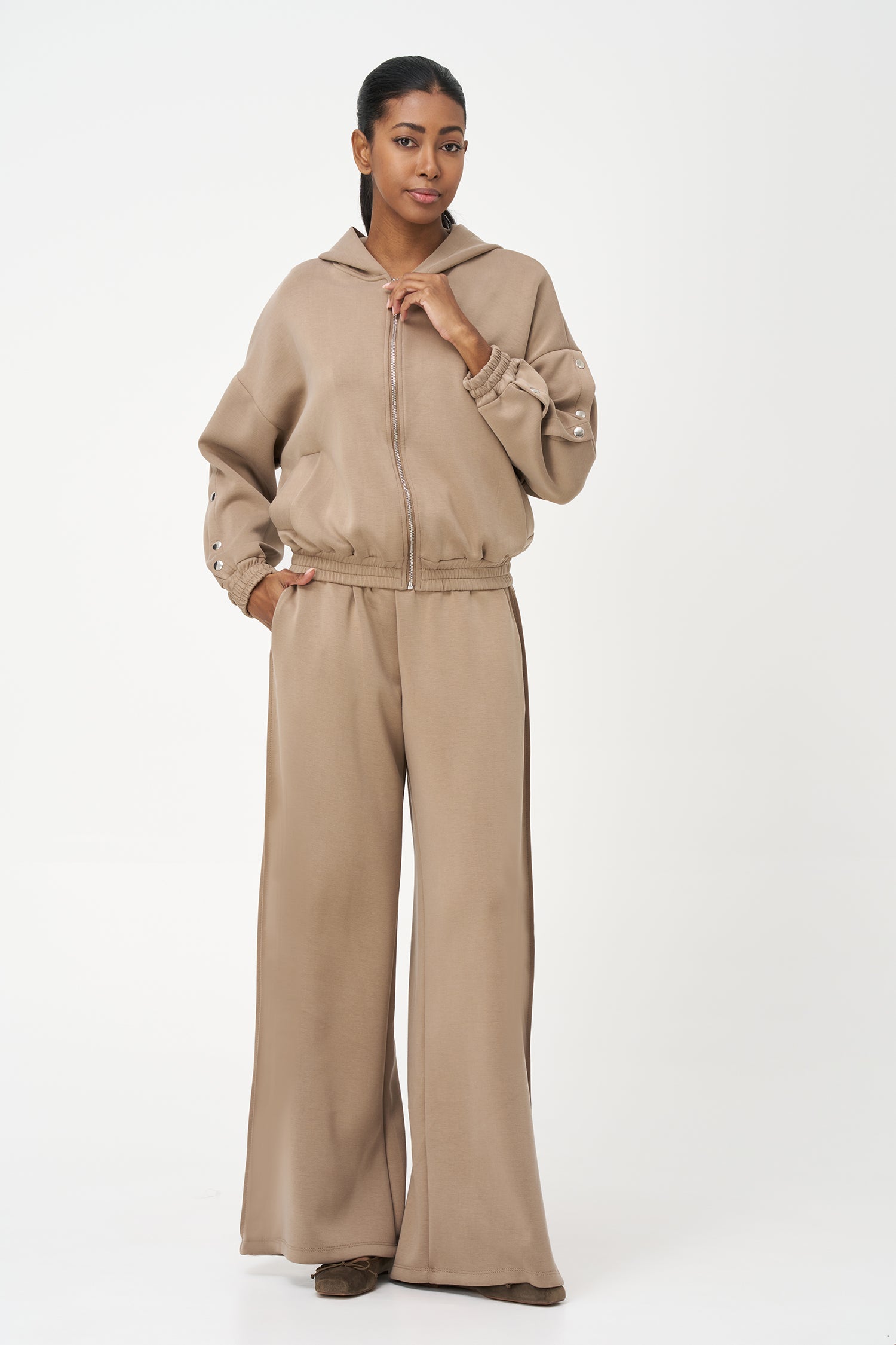 Beige zip-up hoodie with snap button sleeves and elastic cuffs and hem