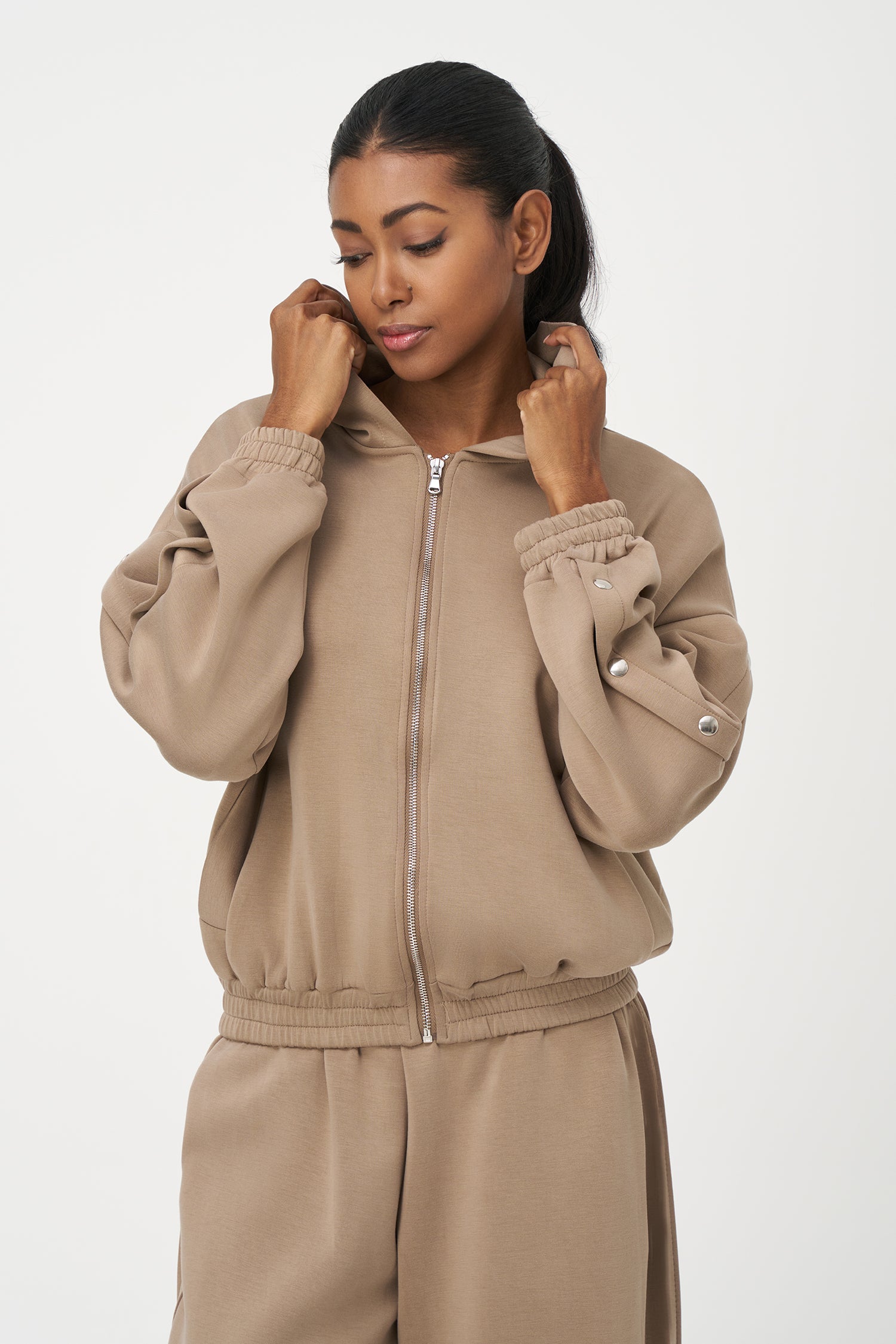 Beige zip-up hoodie with snap button sleeves and elastic cuffs and hem