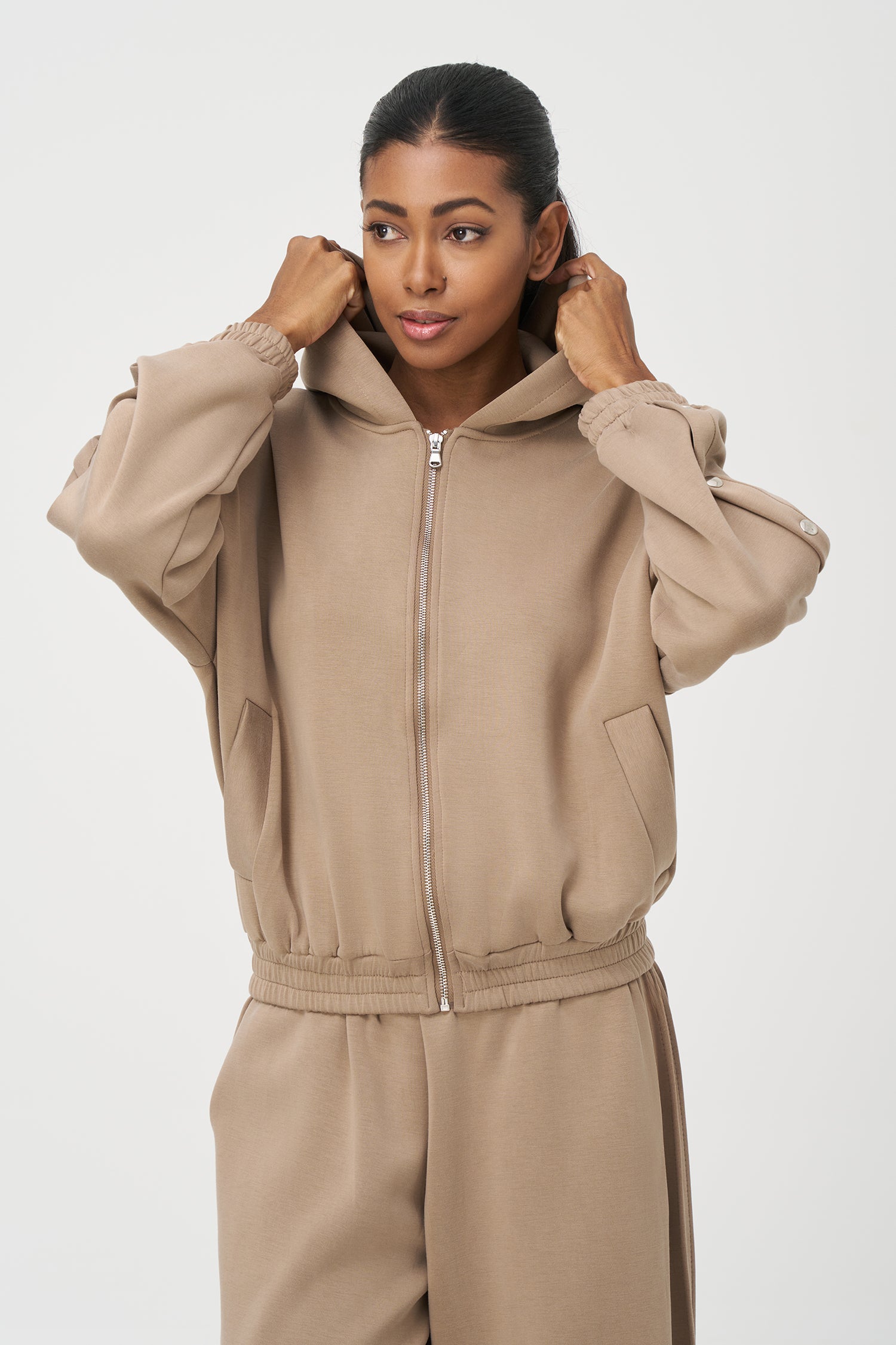 Beige zip-up hoodie with snap button sleeves and elastic cuffs and hem