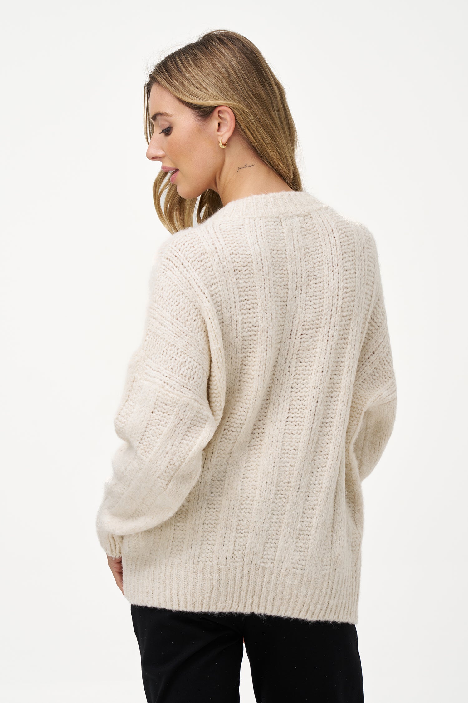 White knit women's sweater with ribbed texture, long sleeves, and wool blend fabric for cozy winter layering.