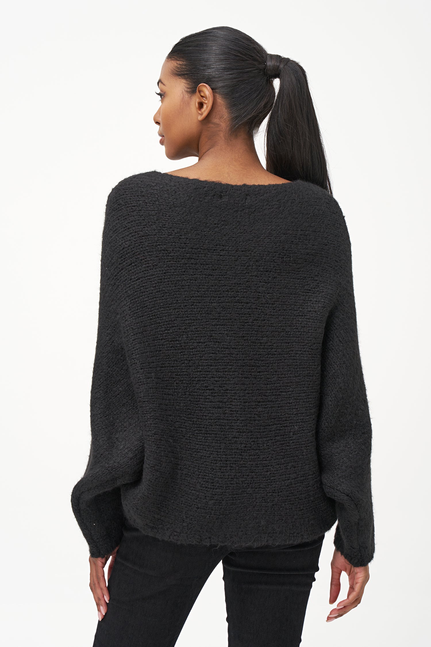 Black acrylic-blend sweater with a soft textured knit, long sleeves, and diagonal front overlay for a relaxed, stylish silhouette.