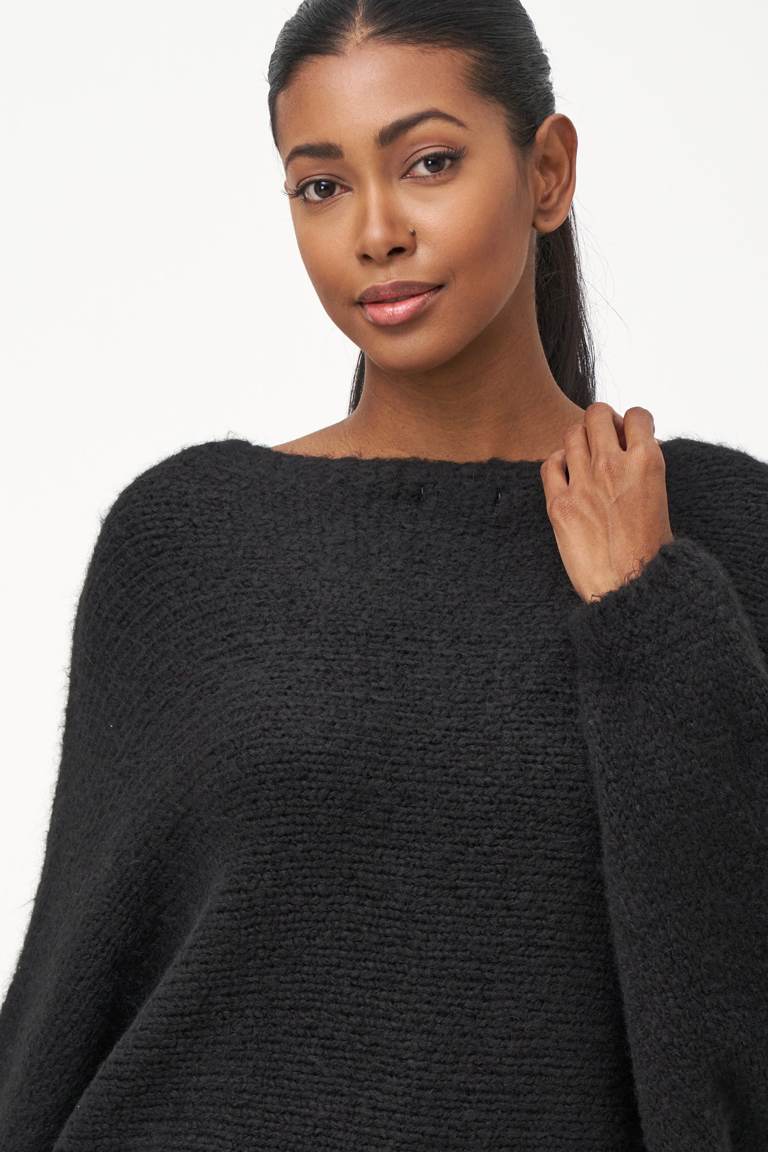 Black acrylic-blend sweater with a soft textured knit, long sleeves, and diagonal front overlay for a relaxed, stylish silhouette.