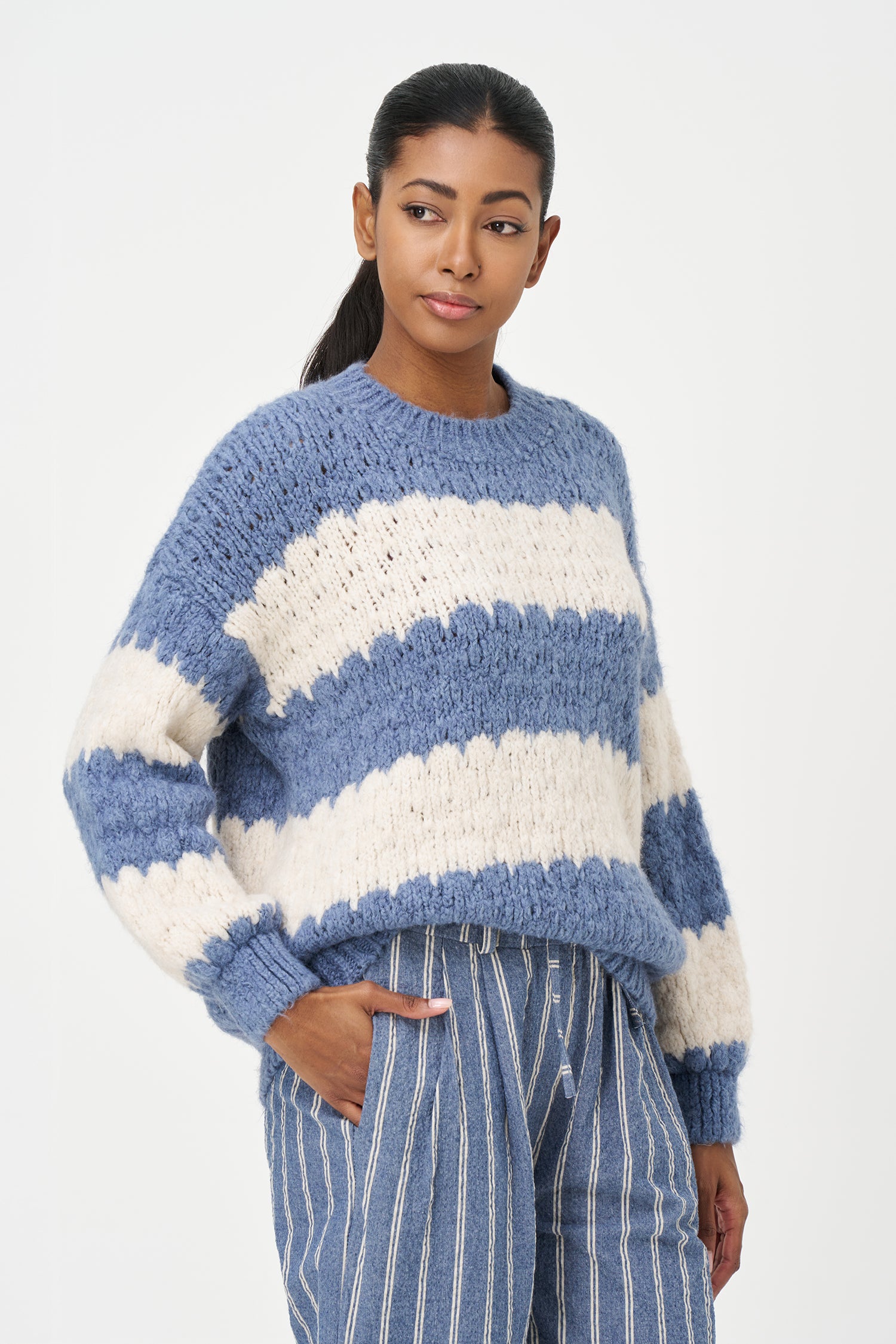 Green-Blue and White striped sweater in soft acrylic blend with a fuzzy texture and relaxed fit, perfect for layering on chilly days.