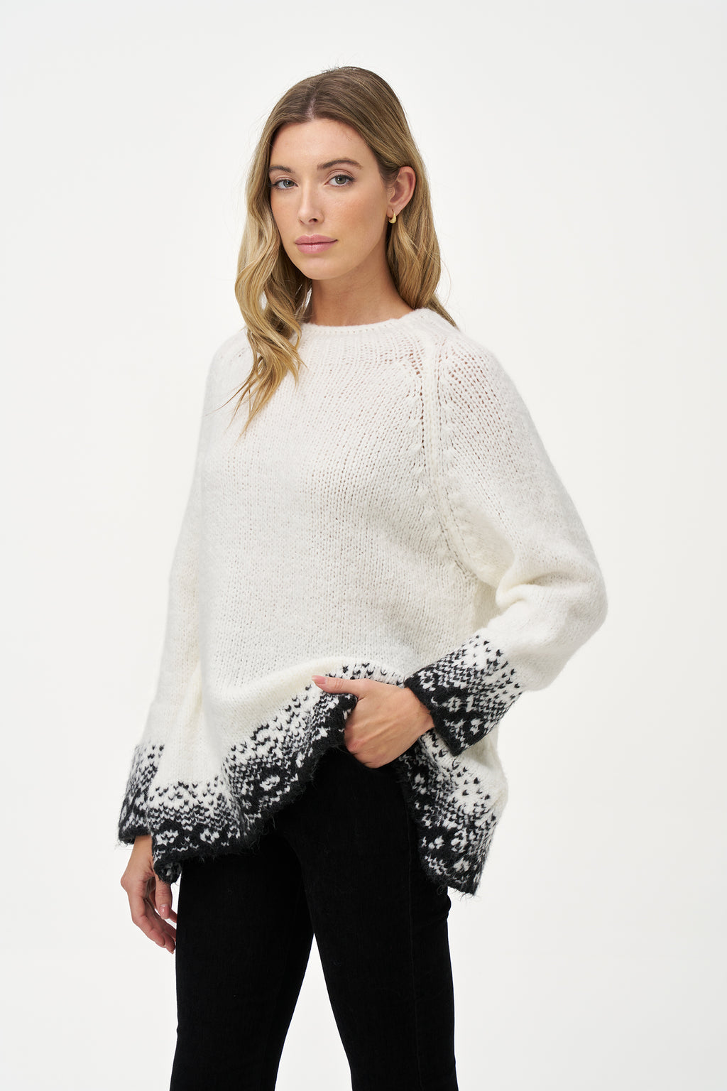 White knit sweater with black jacquard trim, soft wool blend texture and relaxed silhouette ideal for layering in cool weather.