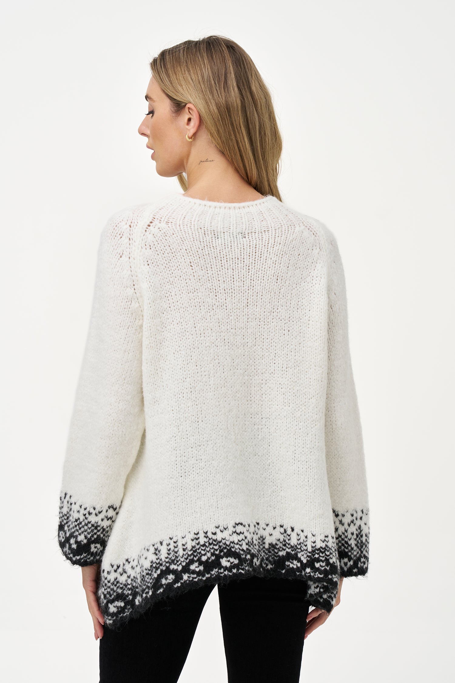 White knit sweater with black jacquard trim, soft wool blend texture and relaxed silhouette ideal for layering in cool weather.