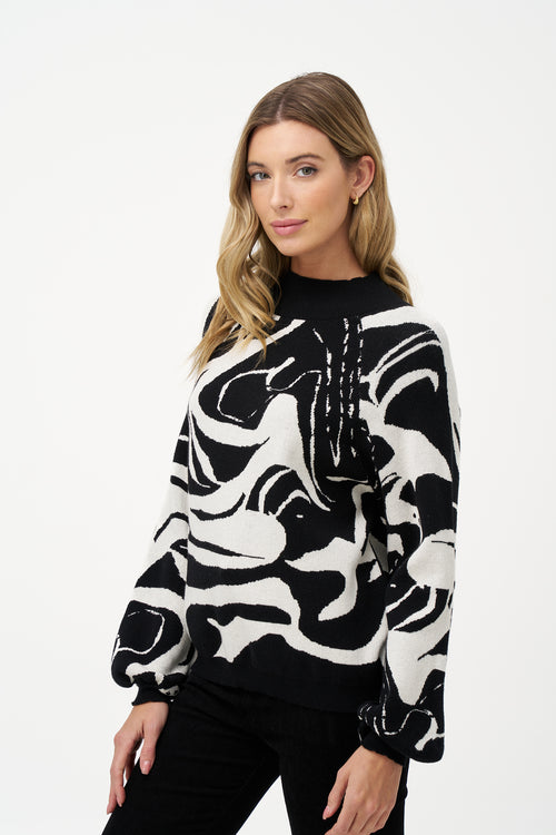 Women's black and white abstract knit sweater with high neckline and puff sleeves in soft viscose blend, perfect for day-to-night outfits and statement layering.