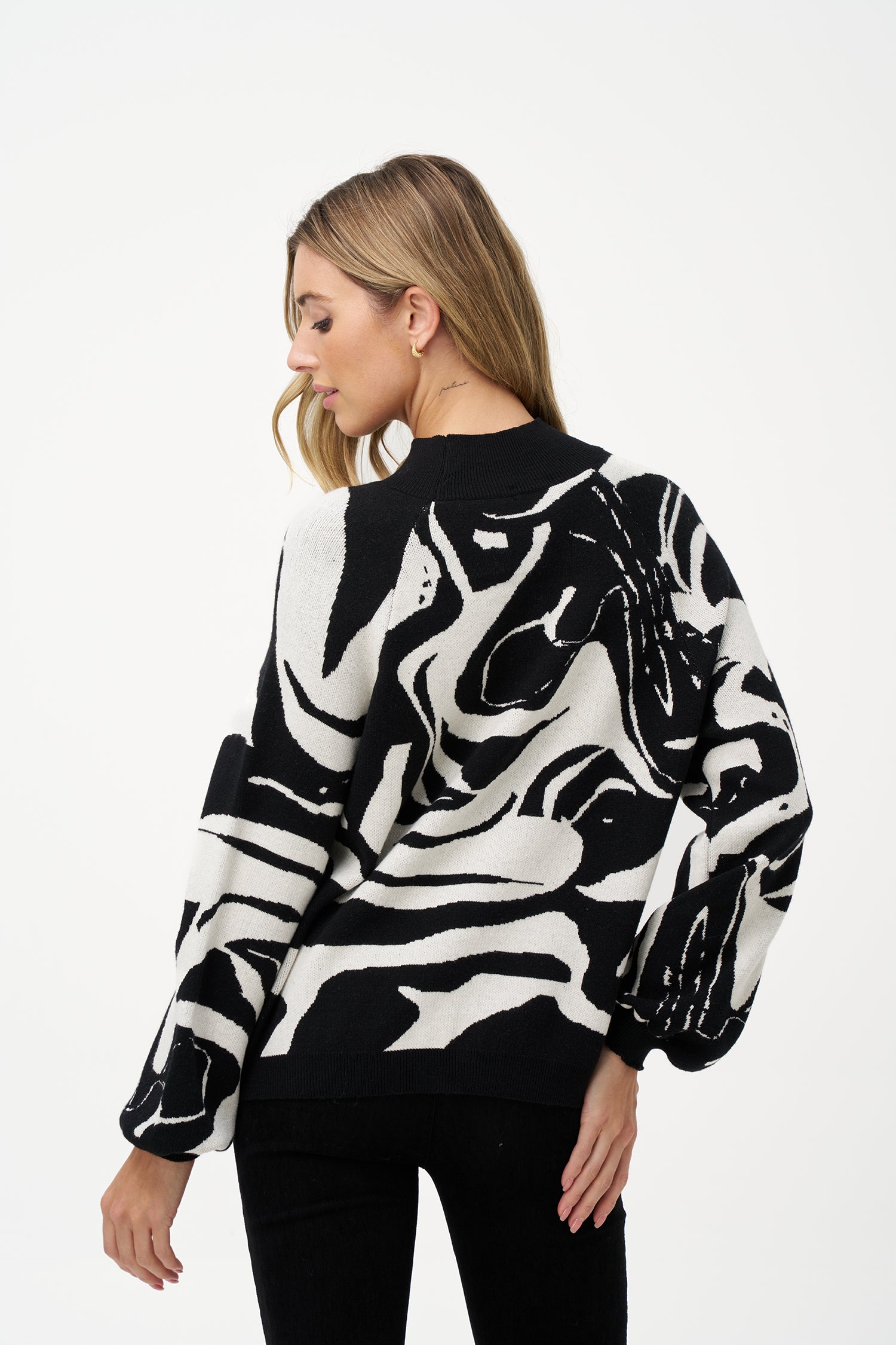 Women's black and white abstract knit sweater with high neckline and puff sleeves in soft viscose blend, perfect for day-to-night outfits and statement layering.