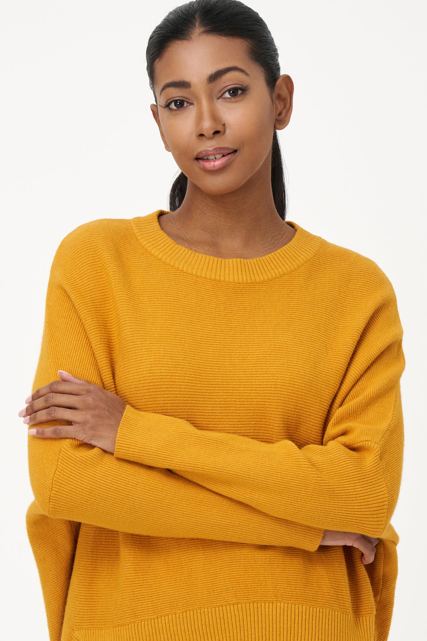 Honey yellow knit sweater with long sleeves and ribbed hem, made in soft viscose wool blend with relaxed fit and clean neckline