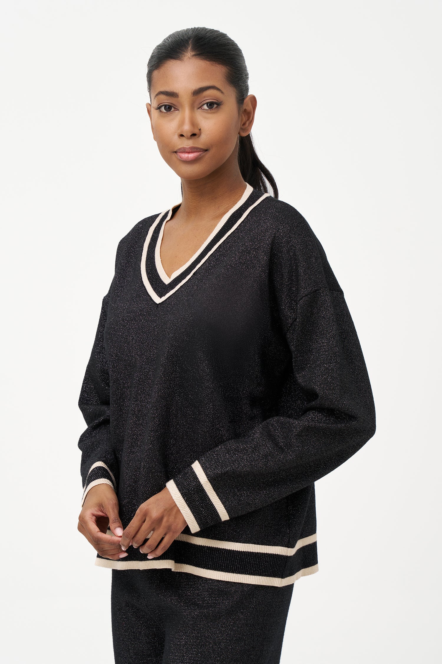Shimmer knit sweater with V-neck and contrast trim details, adding a refined touch to both daytime and evening looks.