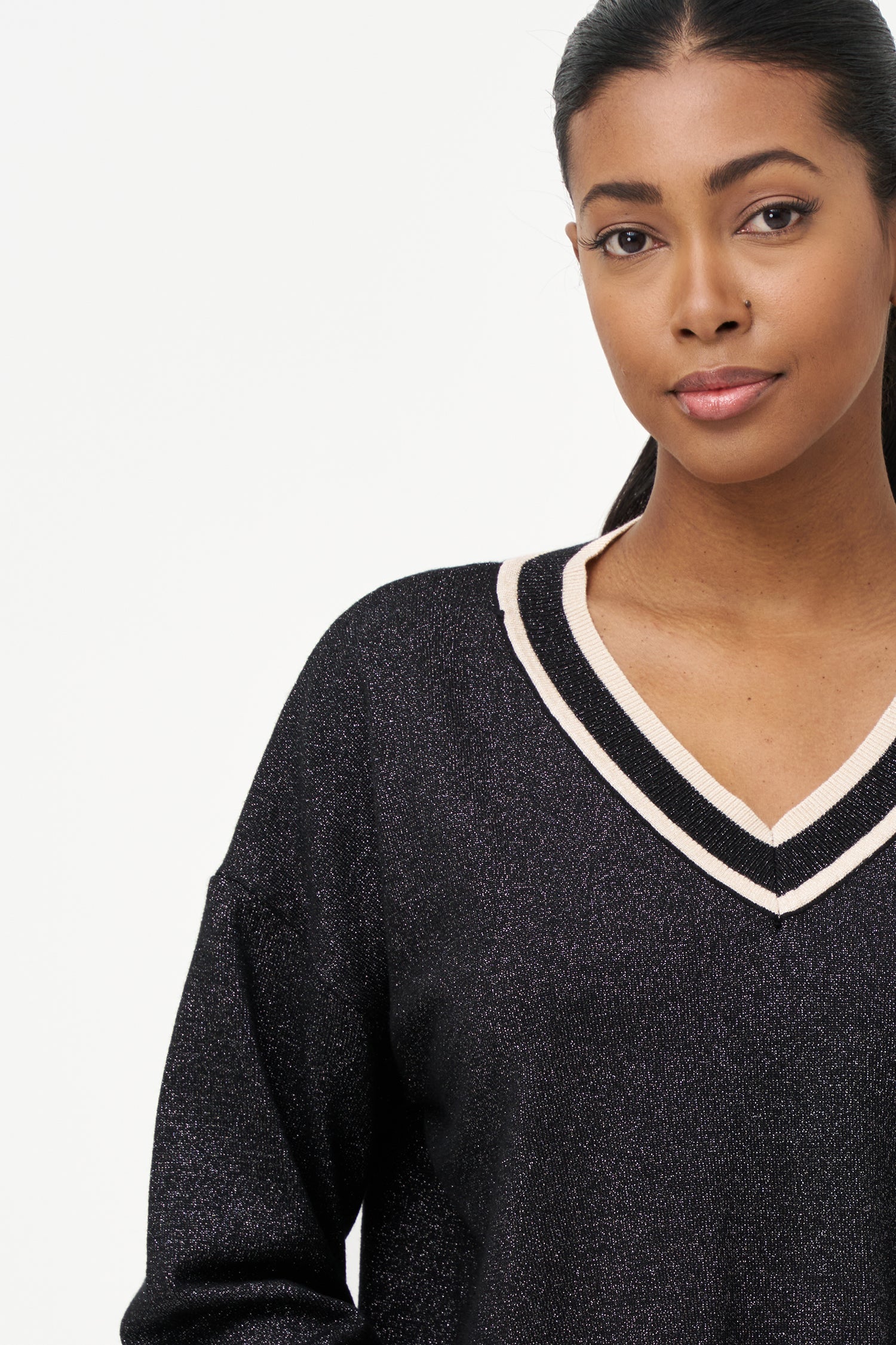 Shimmer knit sweater with V-neck and contrast trim details, adding a refined touch to both daytime and evening looks.