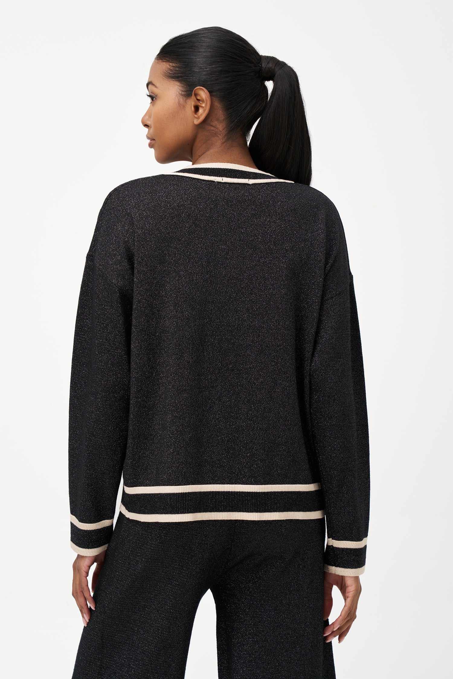 Shimmer knit sweater with V-neck and contrast trim details, adding a refined touch to both daytime and evening looks.