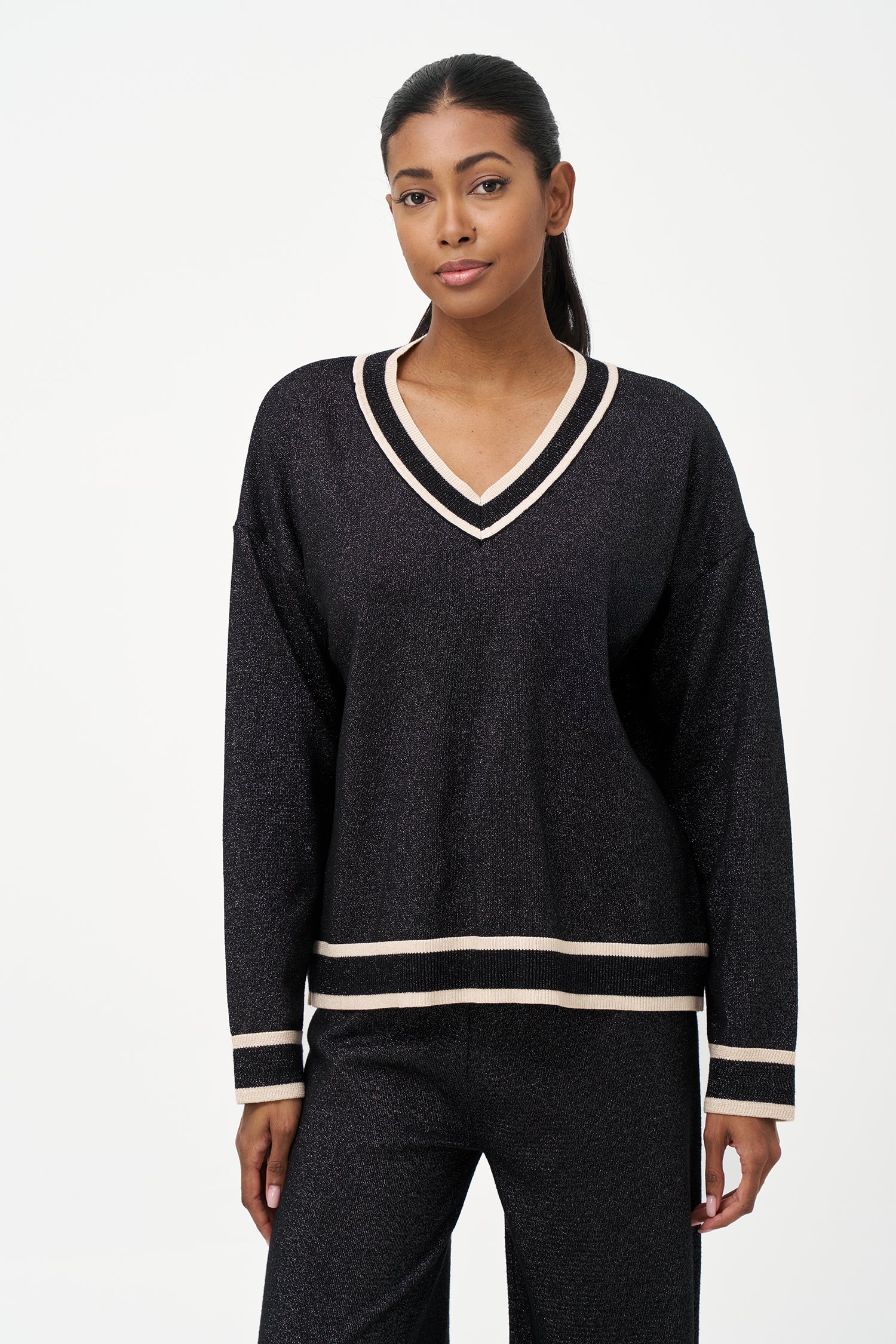 Shimmer knit sweater with V-neck and contrast trim details, adding a refined touch to both daytime and evening looks.