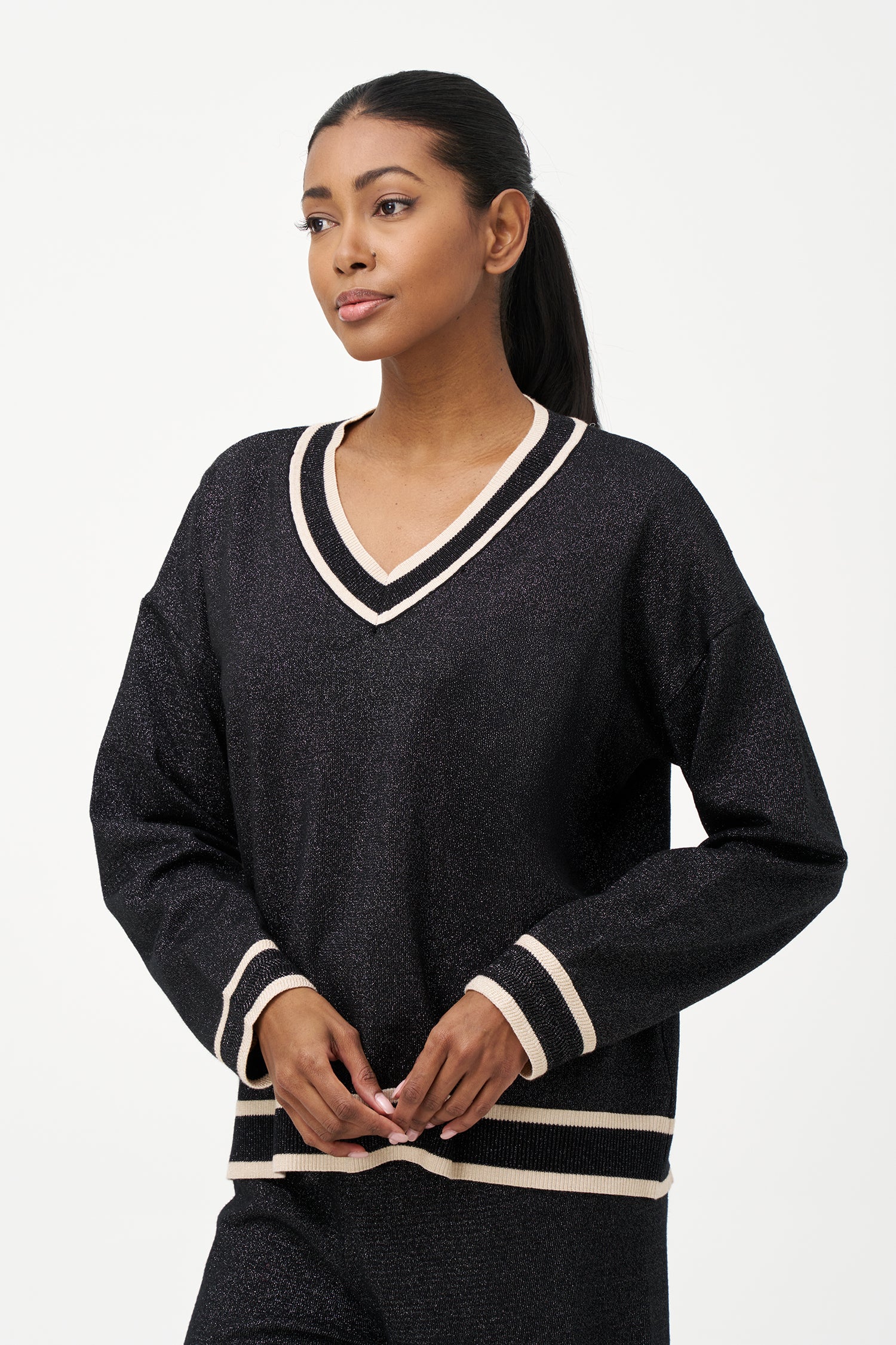 Shimmer knit sweater with V-neck and contrast trim details, adding a refined touch to both daytime and evening looks.
