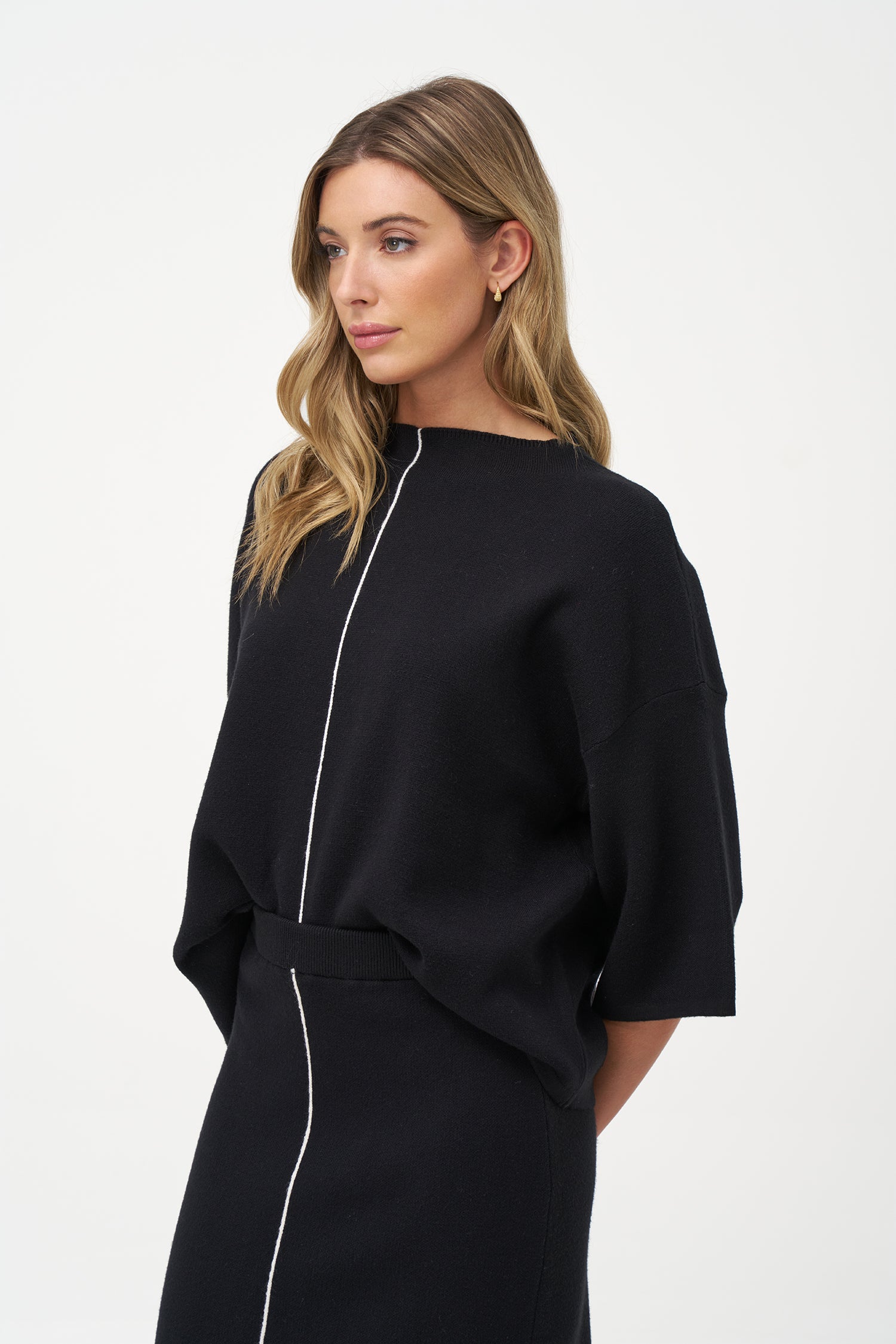 Minimalist wide-sleeve pullover with contrast center seam, featuring a relaxed fit and refined drape for versatile everyday styling.