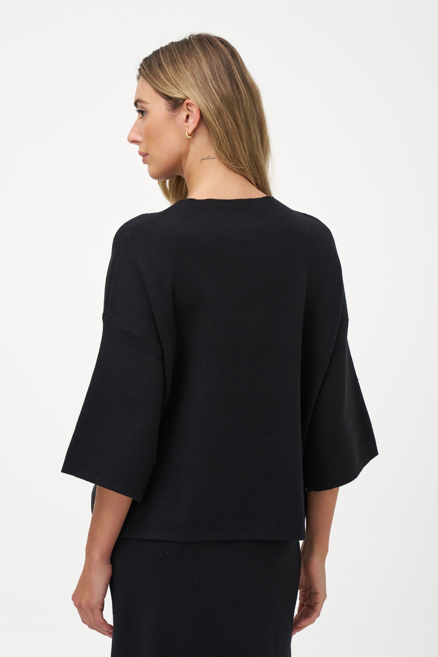 Minimalist wide-sleeve pullover with contrast center seam, featuring a relaxed fit and refined drape for versatile everyday styling.