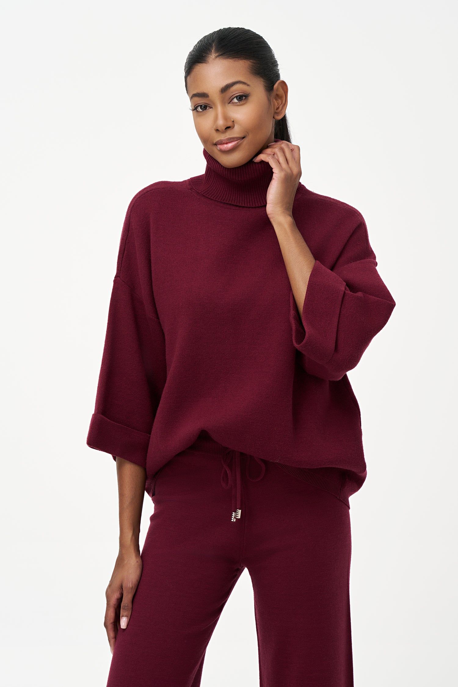 red turtleneck top with wide 3/4 sleeves, folded cuffs, and a structured silhouette for casual or polished styling.