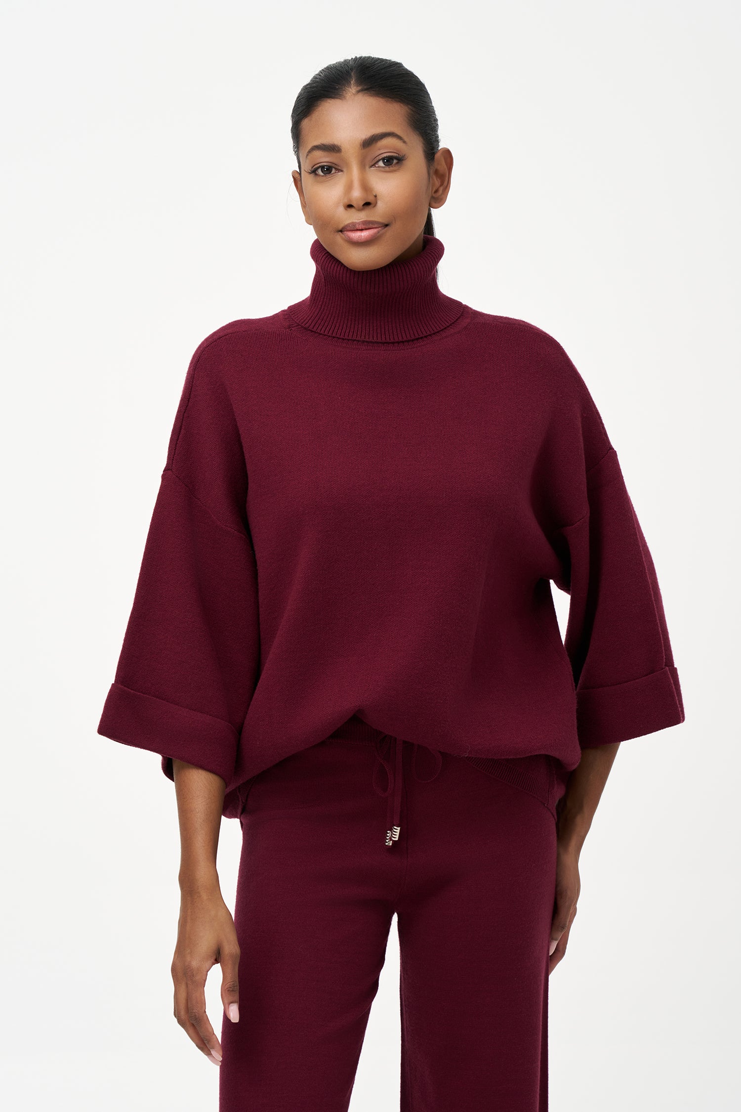 red turtleneck top with wide 3/4 sleeves, folded cuffs, and a structured silhouette for casual or polished styling.