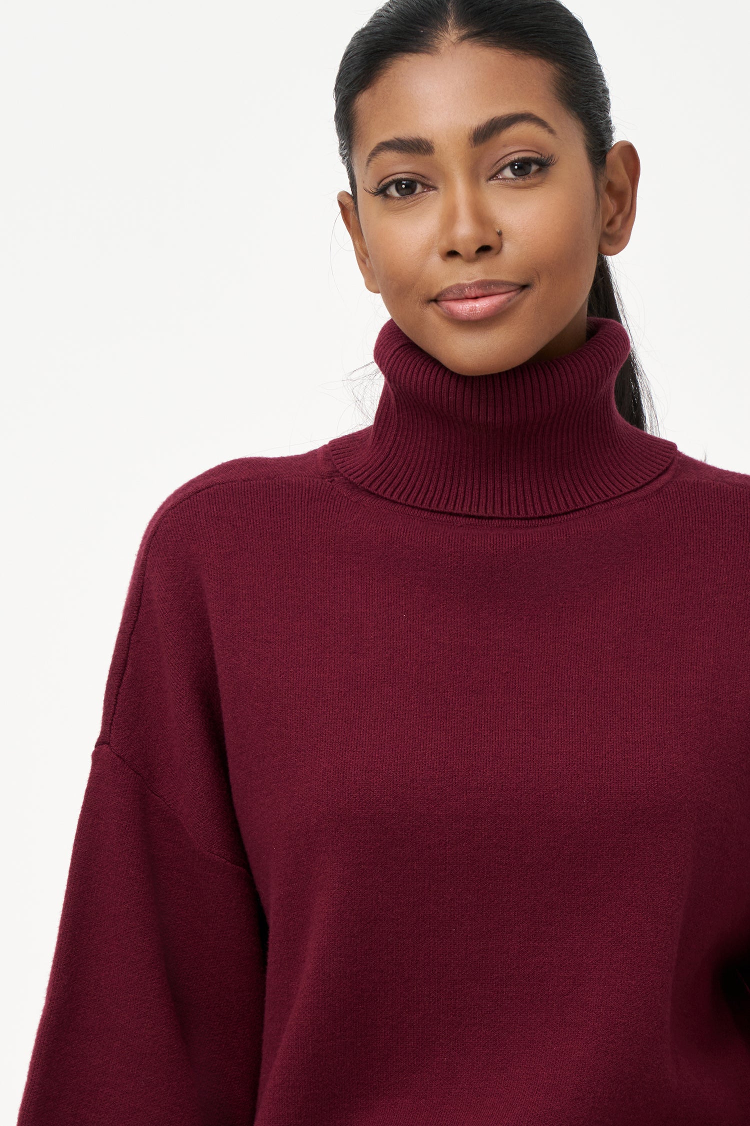 red turtleneck top with wide 3/4 sleeves, folded cuffs, and a structured silhouette for casual or polished styling.