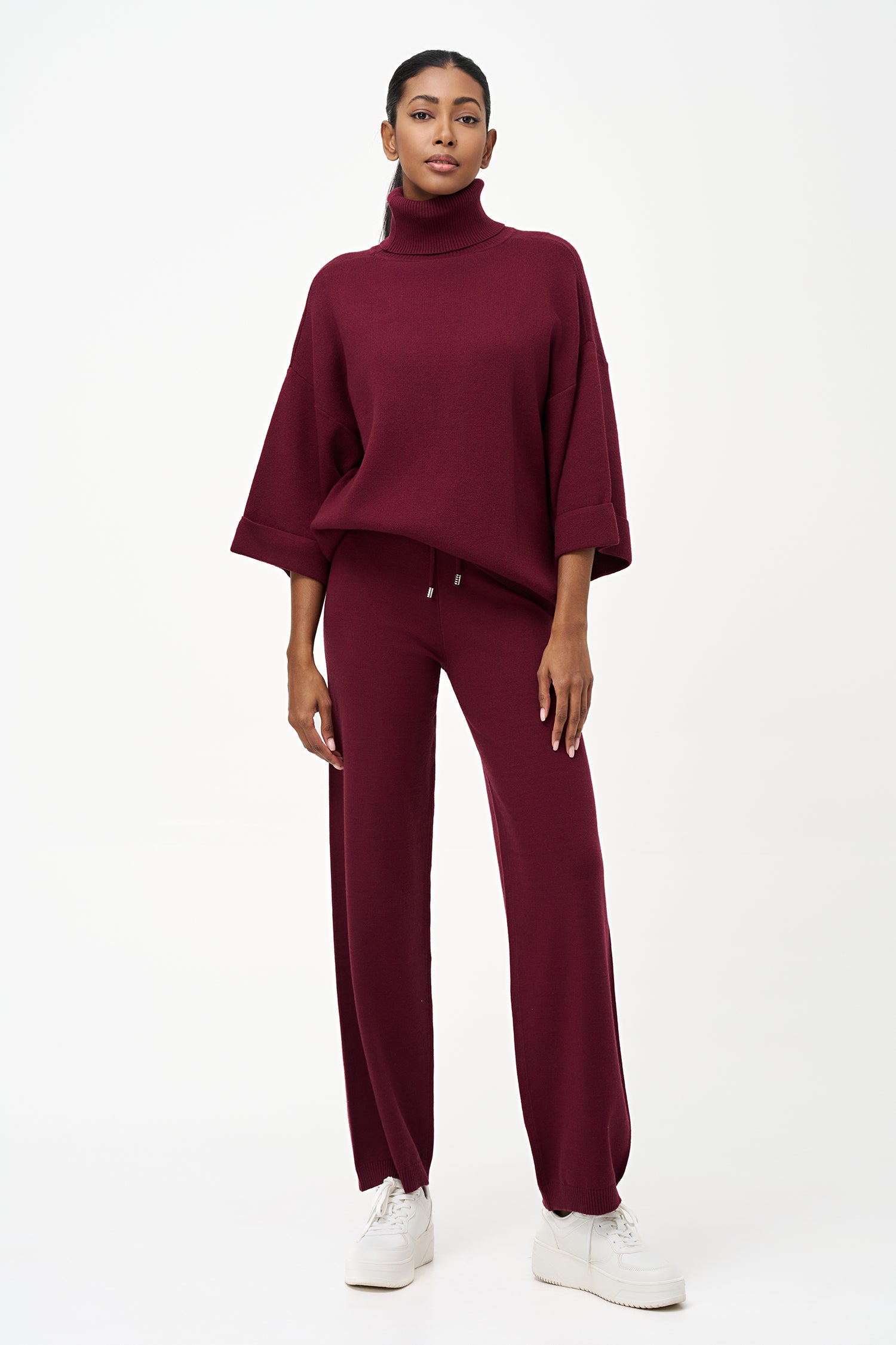 red turtleneck top with wide 3/4 sleeves, folded cuffs, and a structured silhouette for casual or polished styling.