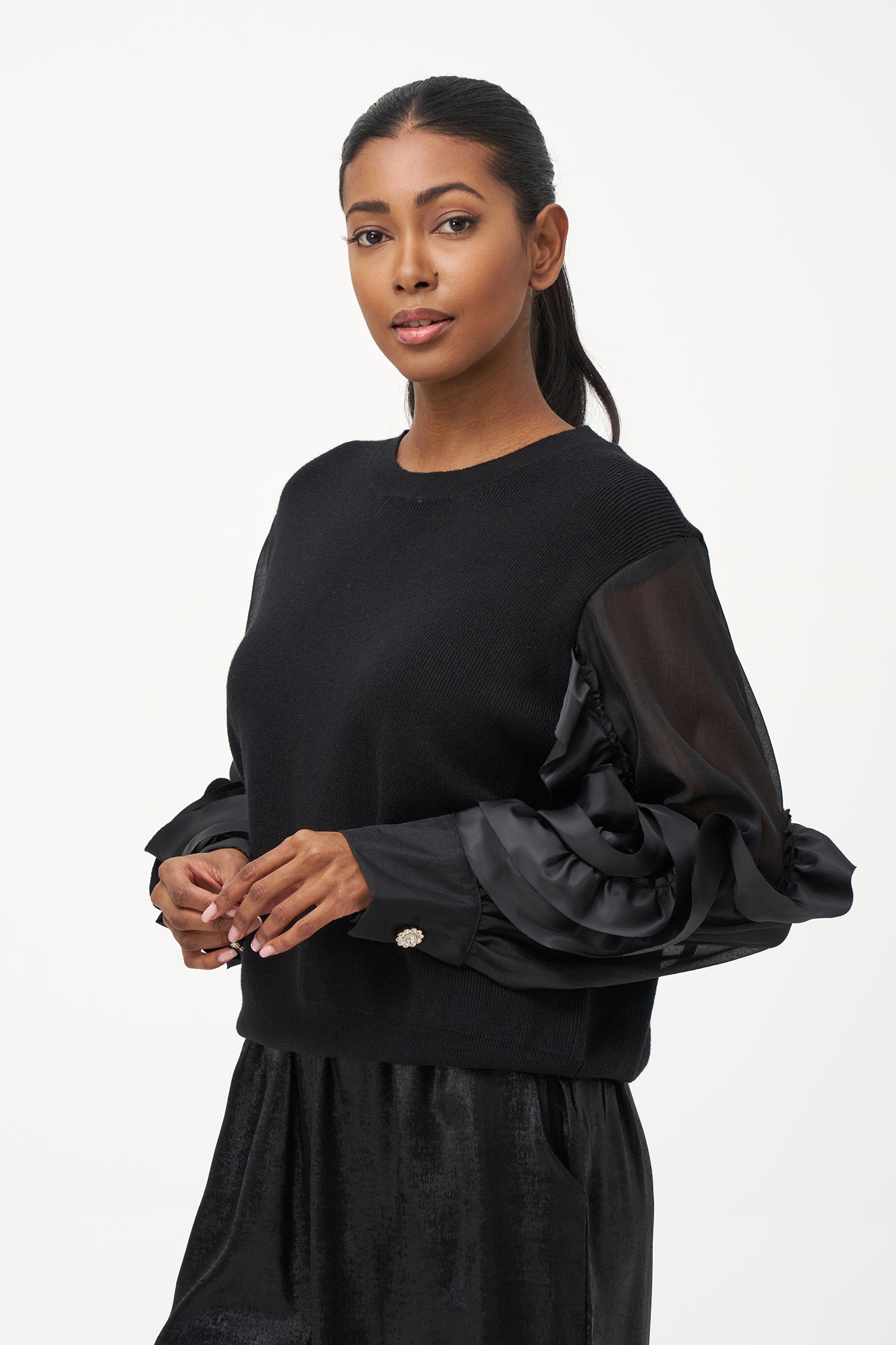 Black crew neck sweater with statement ruffled satin sleeves and contrast textures for a bold, fashion-forward silhouette.